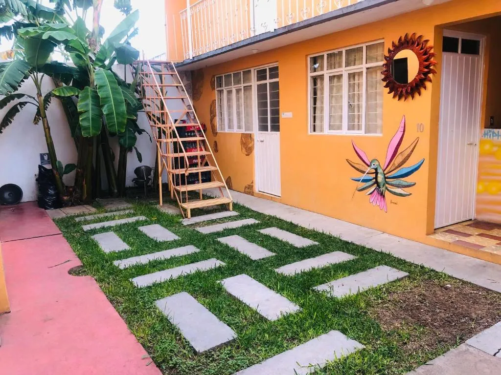 Patio with grass, a wooden stairway and a hummingbird mural