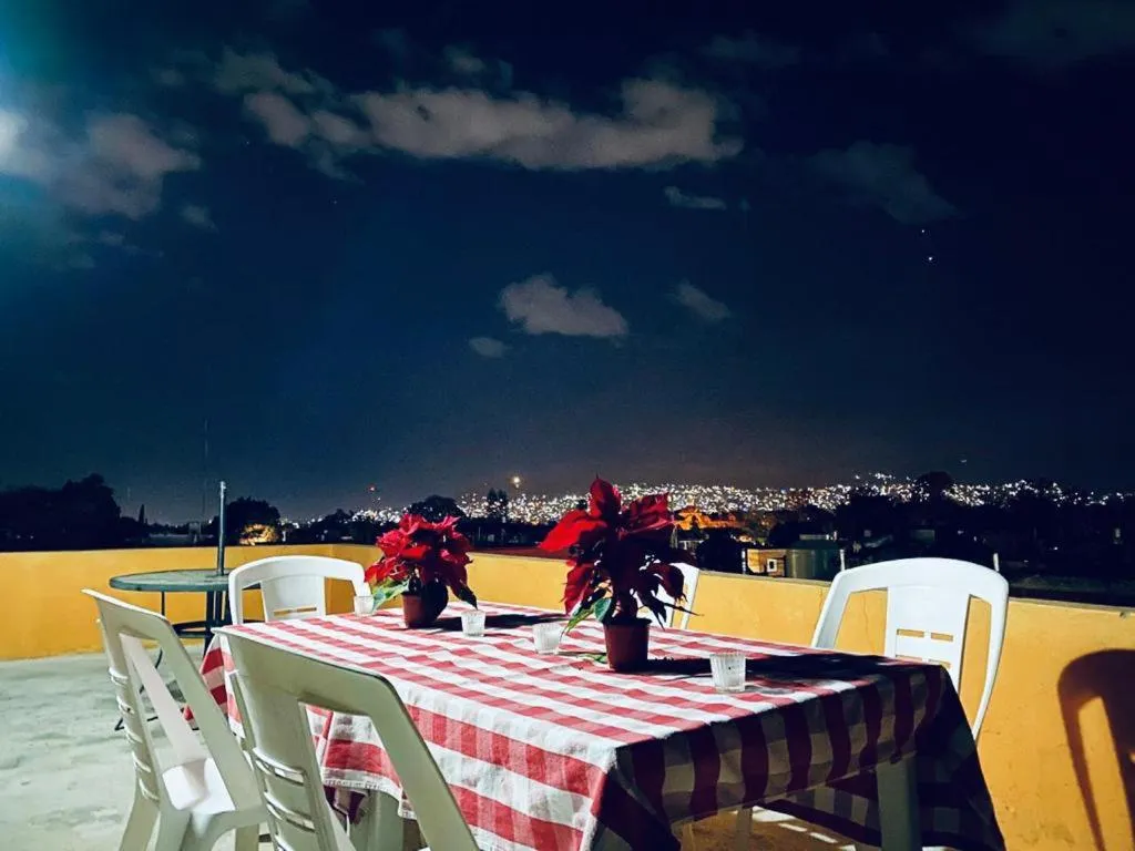 Hostel rooftop at night with a view over the city